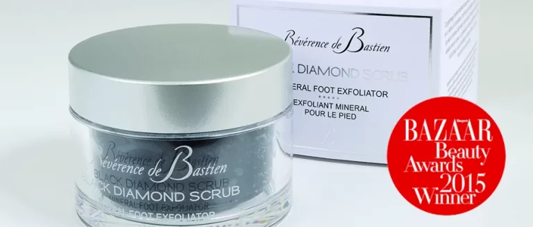 A jar of Révérence de Bastien Black Diamond Scrub, a mineral foot exfoliator, is displayed alongside its white packaging box. A red Bazaar Beauty Awards 2015 Winner badge is prominently featured on the right side of the image.