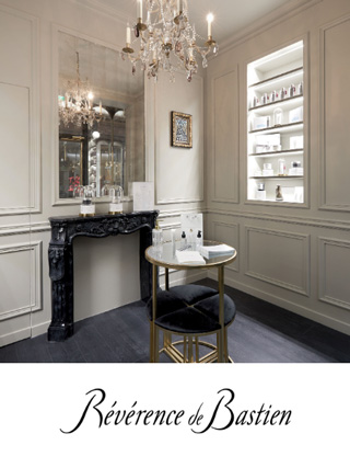 Un intérieur chic et élégant d'une boutique avec des murs lambrissés blancs et une grande cheminée noire ornée.